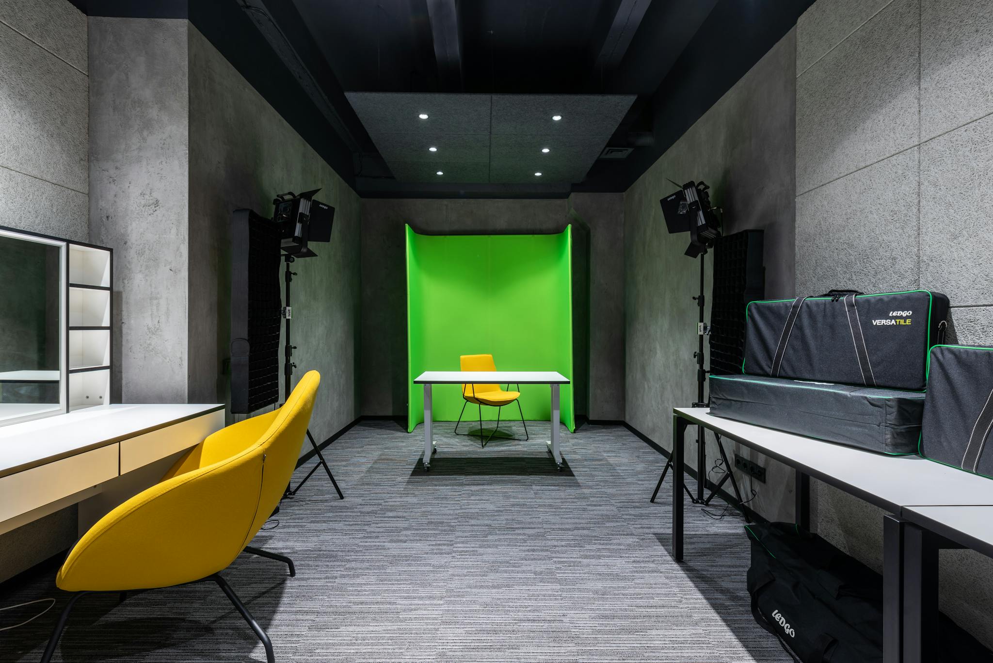 Contemporary studio interior with green screen, lighting, and seating. Ideal for creative projects.